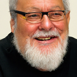 Pixel+LILIE sample for: A man with gray hair and a white beard smiles while wearing glasses and a black