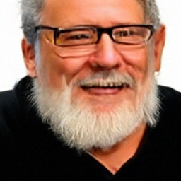 Pixel sample for: A man with gray hair and a white beard smiles while wearing glasses and a black